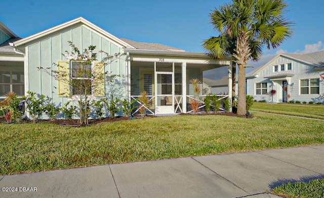 view of front of home with a front yard and a sunroom