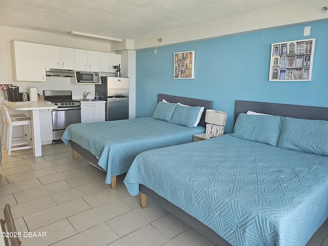 701 S Atlantic Ave Unit 218, Daytona Beach, FL 32118 - bedroom with freestanding refrigerator, a textured ceiling, light tile patterned floors, and a sink