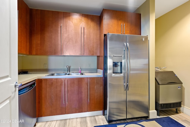 1925 S Atlantic Ave Unit 205, Daytona Beach Shores, FL 32118 - kitchen with stainless steel appliances, a sink, light countertops, light wood-style floors, and brown cabinetry