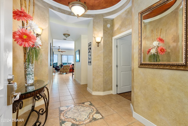 corridor featuring light tile patterned flooring and ornamental molding