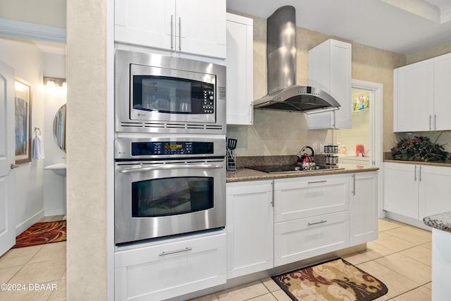 1925 S Atlantic Ave Unit 205, Daytona Beach Shores, FL 32118 - kitchen with stainless steel appliances, wall chimney exhaust hood, light tile patterned flooring, and white cabinets