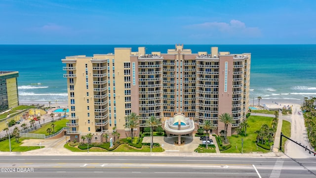 view of building exterior featuring a beach view and a water view