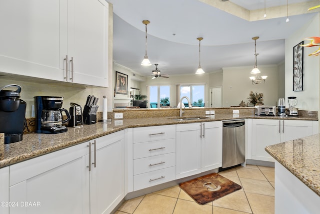 kitchen with light stone countertops, sink, hanging light fixtures, stainless steel dishwasher, and white cabinets