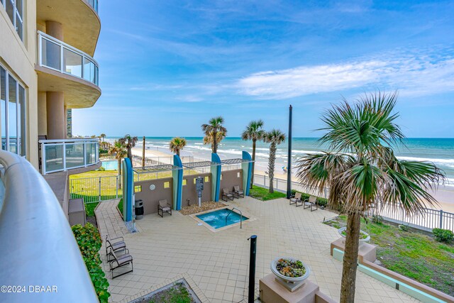 view of patio / terrace with a water view and a beach view