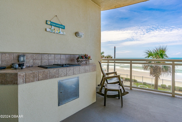 balcony with area for grilling, a water view, and a view of the beach