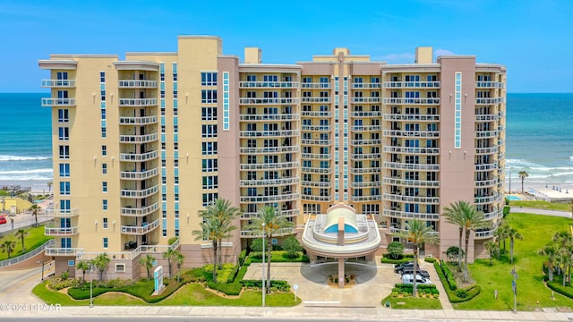 view of building exterior with a water view and a view of the beach