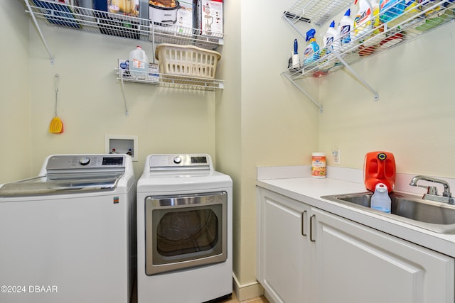 washroom featuring cabinets, washer and clothes dryer, and sink