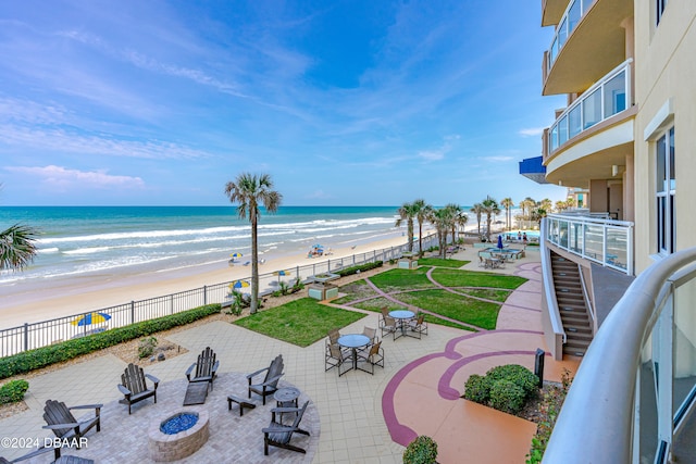 view of water feature with a beach view and a fire pit