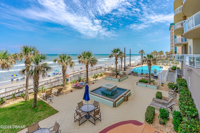 view of patio / terrace featuring a water view and a beach view