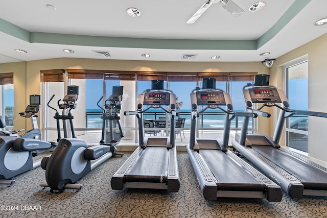 exercise room featuring a water view