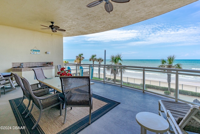 balcony with ceiling fan, a water view, and a beach view