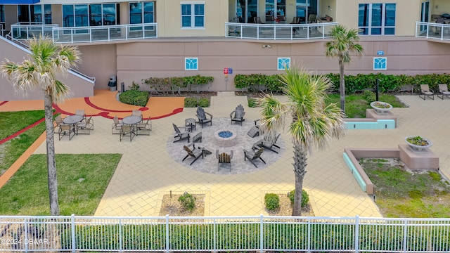 view of property's community featuring a patio area and an outdoor fire pit