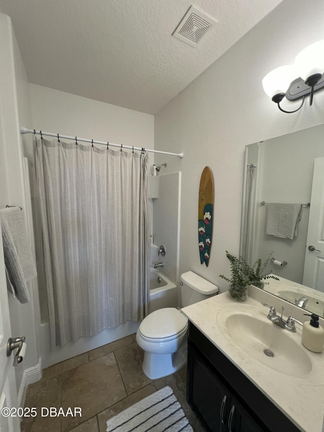 full bathroom with shower / bath combination with curtain, vanity, a textured ceiling, tile patterned flooring, and toilet