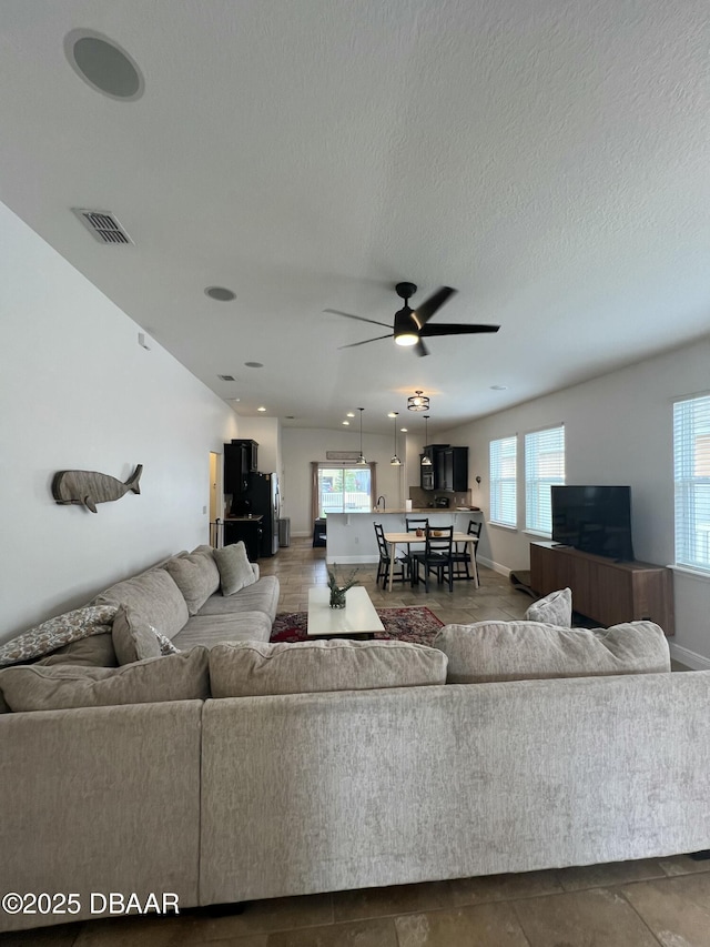 living room with ceiling fan and plenty of natural light