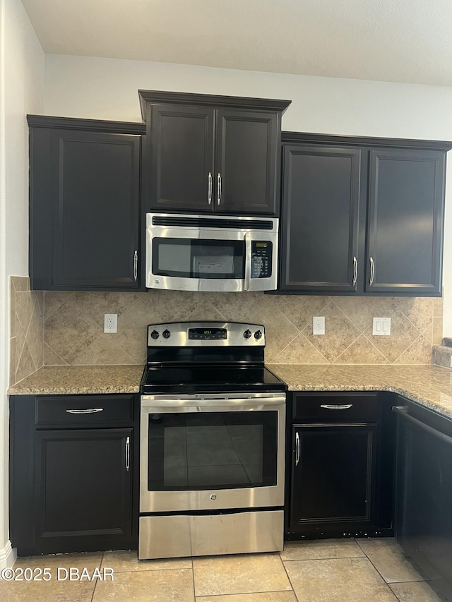 kitchen with backsplash, light stone countertops, light tile patterned floors, and stainless steel appliances