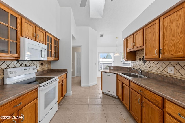 7 Sea Park Ter, Ormond Beach, FL 32176 - kitchen with white appliances, brown cabinets, a sink, and dark countertops