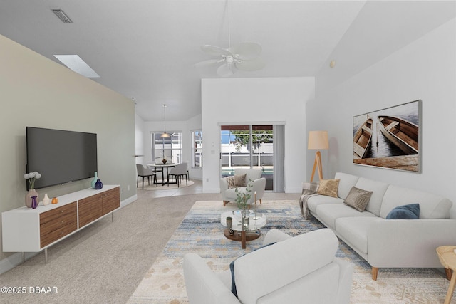 7 Sea Park Ter, Ormond Beach, FL 32176 - living room featuring ceiling fan, visible vents, light carpet, baseboards, and lofted ceiling with skylight