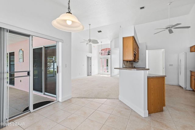 7 Sea Park Ter, Ormond Beach, FL 32176 - kitchen with baseboards, light tile patterned floors, freestanding refrigerator, a ceiling fan, and brown cabinetry