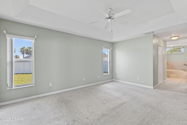 7 Sea Park Ter, Ormond Beach, FL 32176 - carpeted spare room with a tray ceiling, baseboards, ceiling fan, and a healthy amount of sunlight