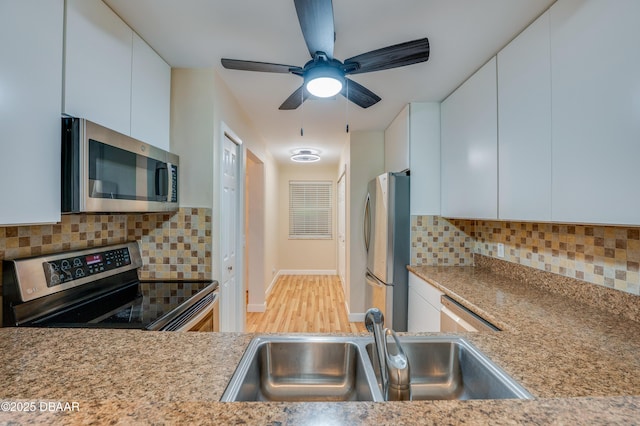 66 Rivers Edge Ln Unit 66, Palm Coast, FL 32137 - kitchen featuring stainless steel appliances, white cabinets, decorative backsplash, and wood finished floors