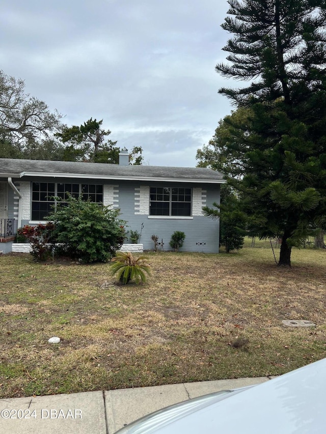 ranch-style home with a front lawn