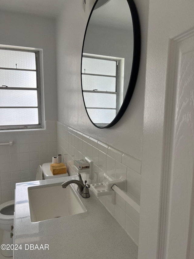 bathroom featuring vanity, toilet, and tile walls