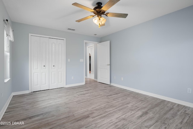 unfurnished bedroom with light hardwood / wood-style flooring, a closet, and ceiling fan