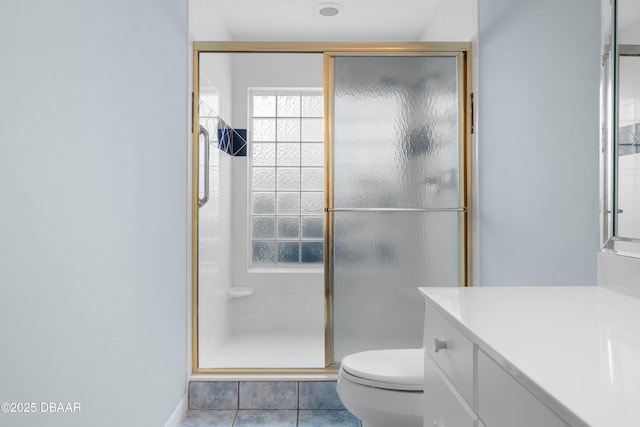 bathroom with an enclosed shower, vanity, toilet, and tile patterned floors