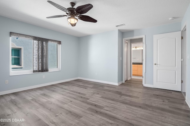 empty room with hardwood / wood-style flooring, ceiling fan, and a textured ceiling