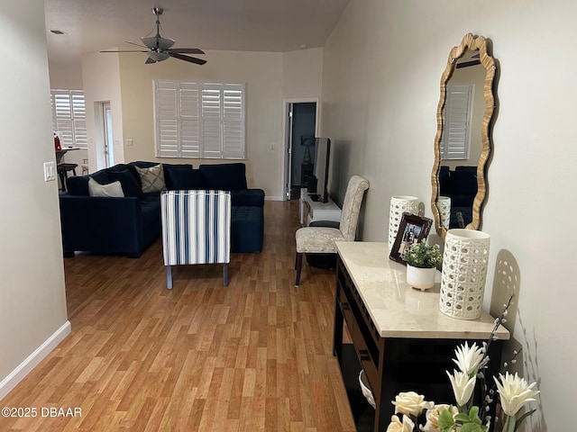 living room with ceiling fan and light hardwood / wood-style flooring