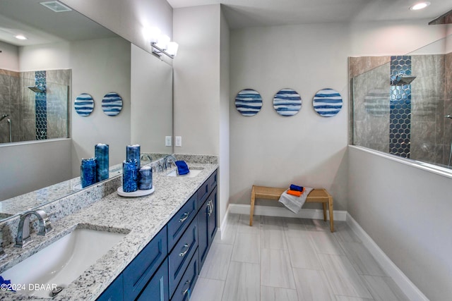 bathroom featuring tiled shower and vanity