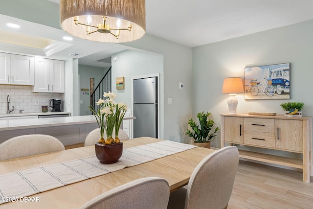 dining room with sink and light wood-type flooring