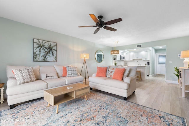 living room featuring light wood-type flooring and ceiling fan