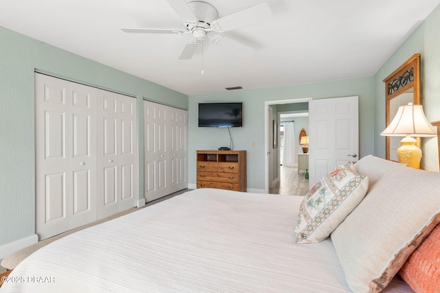 bedroom featuring ceiling fan and multiple closets