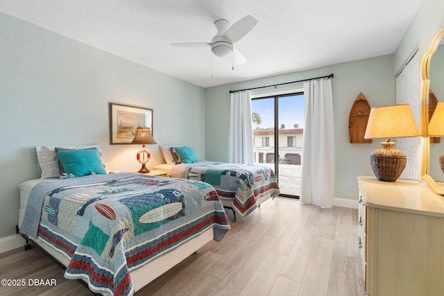 bedroom featuring ceiling fan, light wood-type flooring, a textured ceiling, and access to exterior