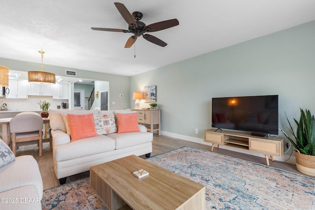 living room featuring ceiling fan and wood-type flooring