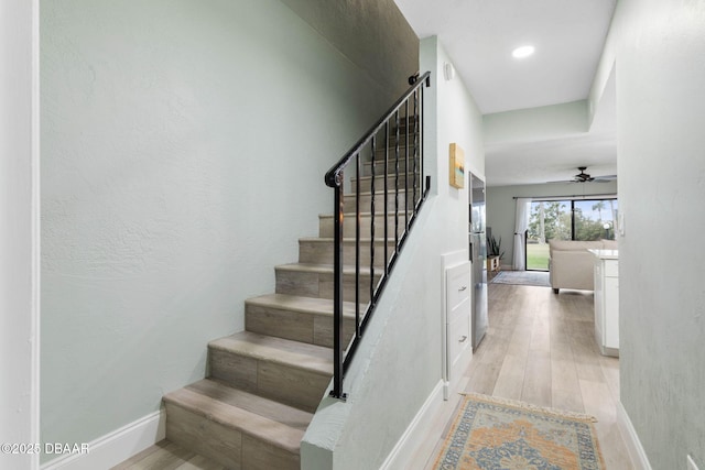 stairway featuring hardwood / wood-style flooring and ceiling fan