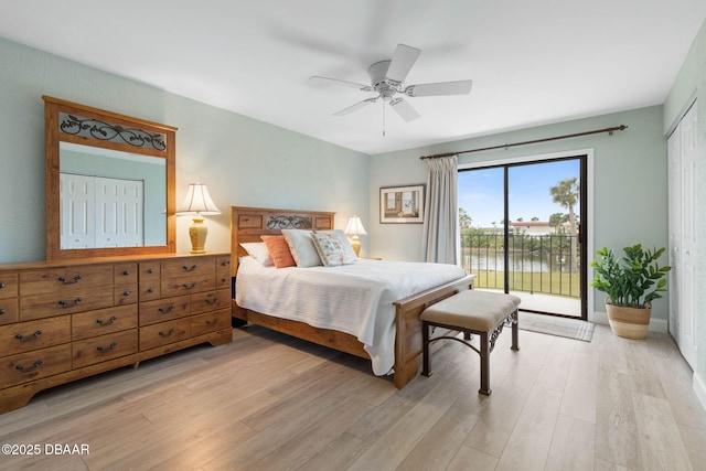 bedroom with a water view, access to exterior, ceiling fan, light hardwood / wood-style flooring, and a closet