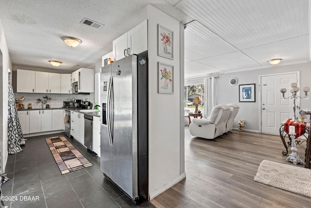 kitchen featuring stainless steel appliances, tasteful backsplash, and white cabinets