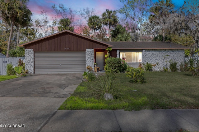 single story home with a garage and a yard