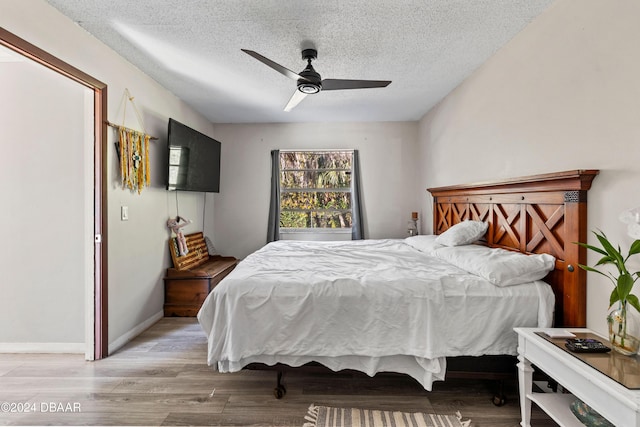 bedroom with ceiling fan, a textured ceiling, and light wood-type flooring