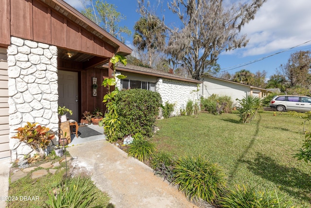 doorway to property featuring a lawn