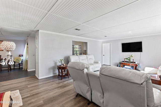 living room featuring hardwood / wood-style flooring and crown molding