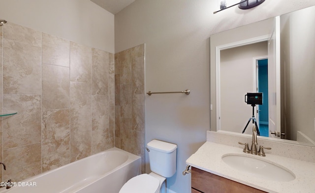 full bathroom with tiled shower / bath, vanity, and toilet