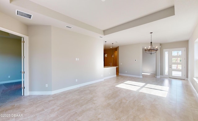 unfurnished room featuring an inviting chandelier