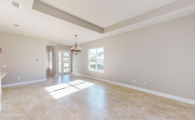 spare room featuring an inviting chandelier