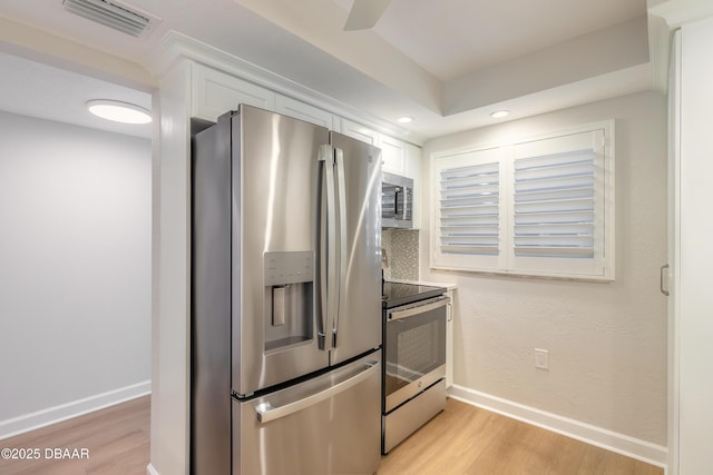 kitchen featuring light wood finished floors, visible vents, appliances with stainless steel finishes, and baseboards