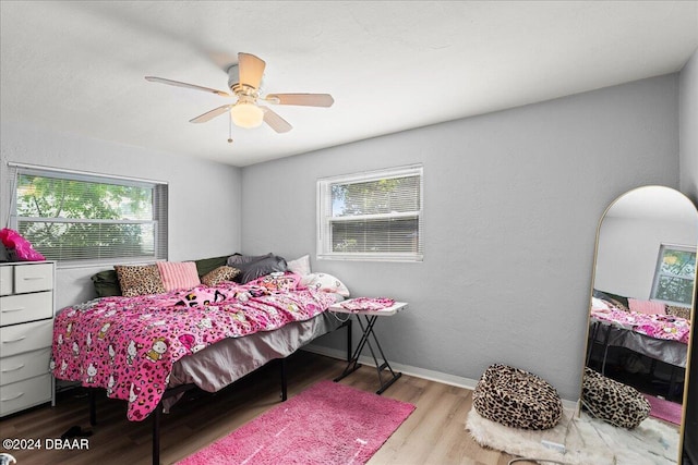 bedroom featuring light hardwood / wood-style floors, multiple windows, and ceiling fan