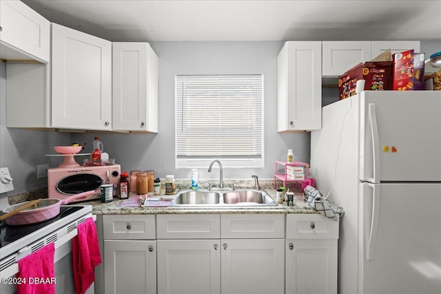 kitchen with white cabinetry, white appliances, sink, and light stone countertops