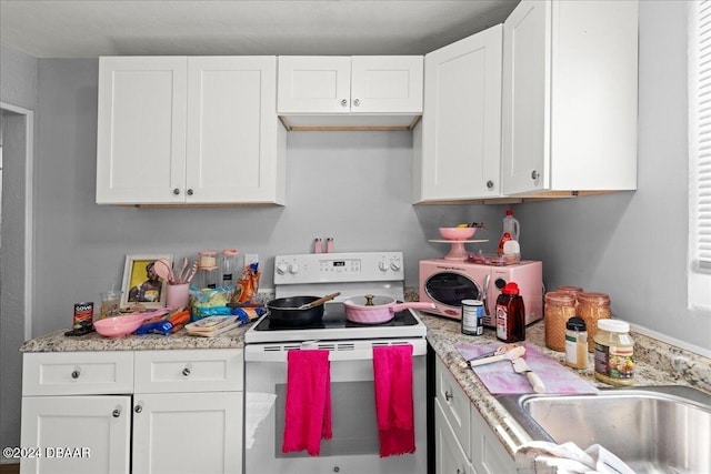 kitchen with white cabinetry, sink, light stone counters, and white range with electric stovetop